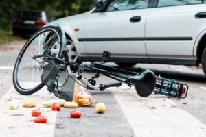 bicycle lying in the street with fruit everywhere after an accident