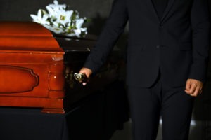 pallbearer carrying a wooden casket