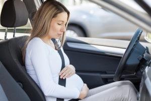 concerned mother-to-be behind the wheel