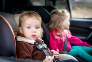 small children in car seats in back seat of car